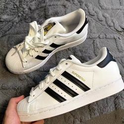 Adidas classic white shell toe sneakers with the three-leaf clover