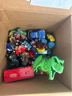 Box of assorted toy cars and dinosaur