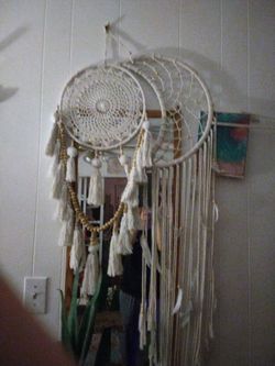 macrame dream catcher features a detailed woven circle and long tassels with wooden beads