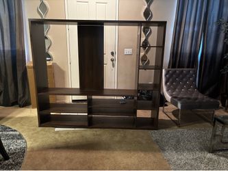 Large brown entertainment center. Only owned a couple of months. Perfect condition and supports a 55’ inch TV (on stand)