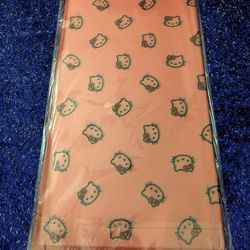 Hello Kitty wrapping paper. 
It features a repeating pattern of the Hello Kitty character's face.
The paper is a peach pink color.
