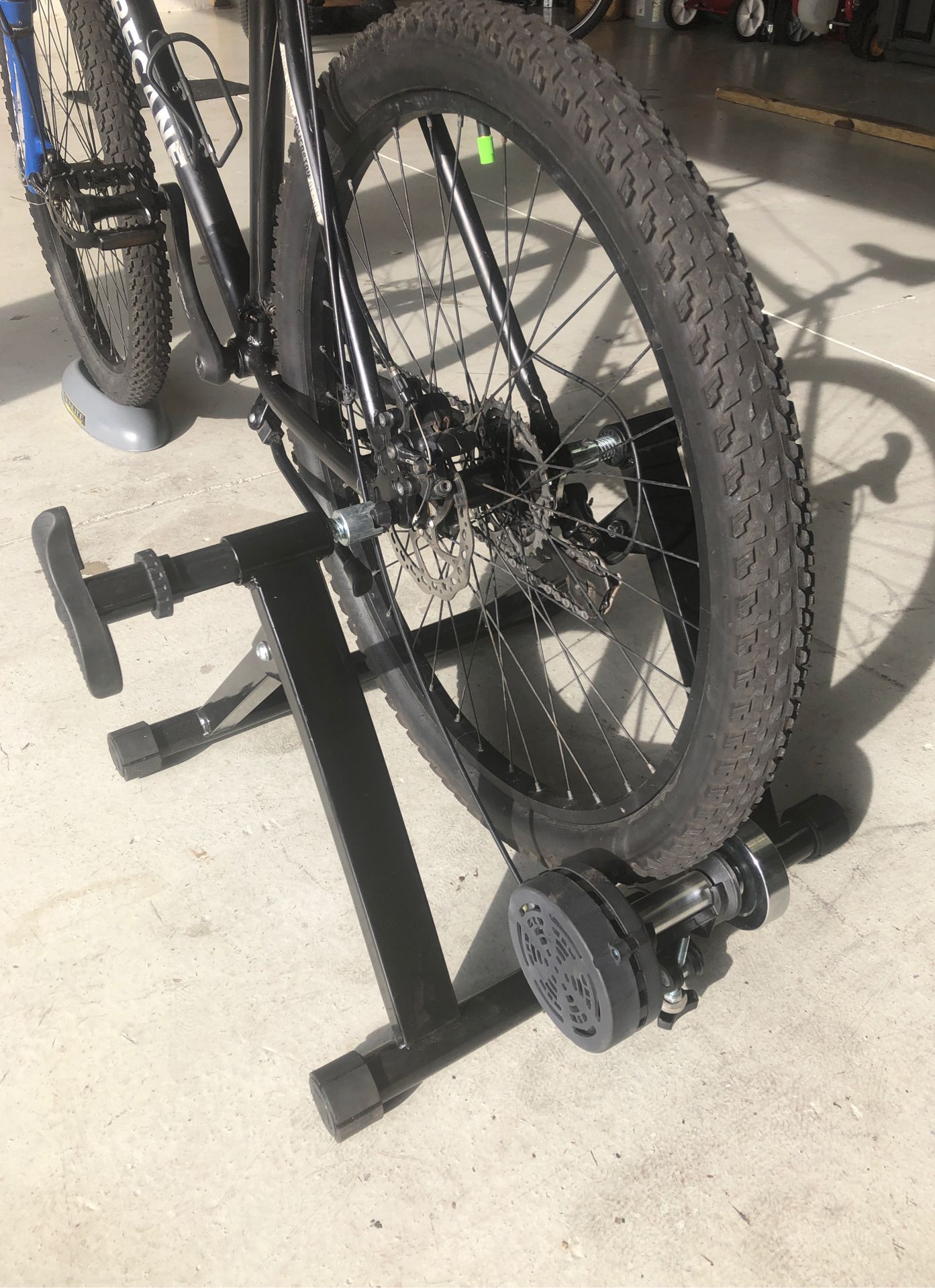 Indoor bicycle trainer with front wheel riser and difficulty control knob.