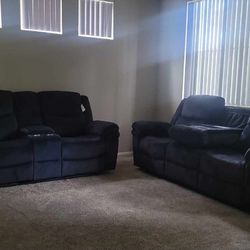 Dark-colored, two-seater reclining loveseat.