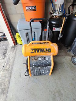 This is a DEWALT 4.5 Gallon Portable Electric Air Compressor, likely model D55146, featuring a collapsible handle and wheels for mobility