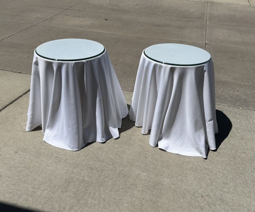 2 Glass Topped End Tables 24” T 20” Diameter