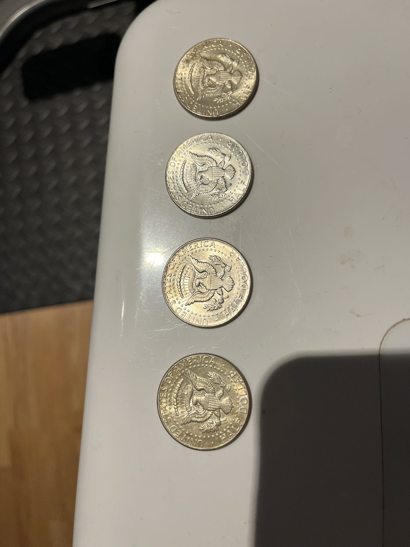 four 1964 kennedy half dollars . two good circulated condition . other two with interesting contrast . 90% silver 