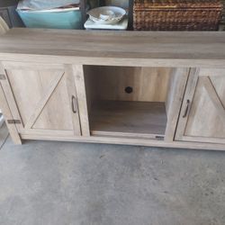 Gray 2 Door Entertainment Stand With Shelving.  Needs Adjustments To Reposition On Left Side. Otherwise Looks Brand New. Sold As Is