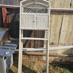 Behind the toilet wicker, shelf.