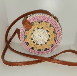 pink and white round sling bag features handcrafted rattan boho