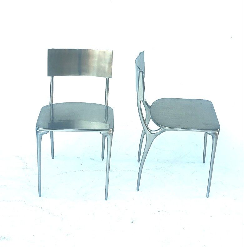 Pair of CB2 Oro Polished Aluminum Dining Chair by Azeeza. 