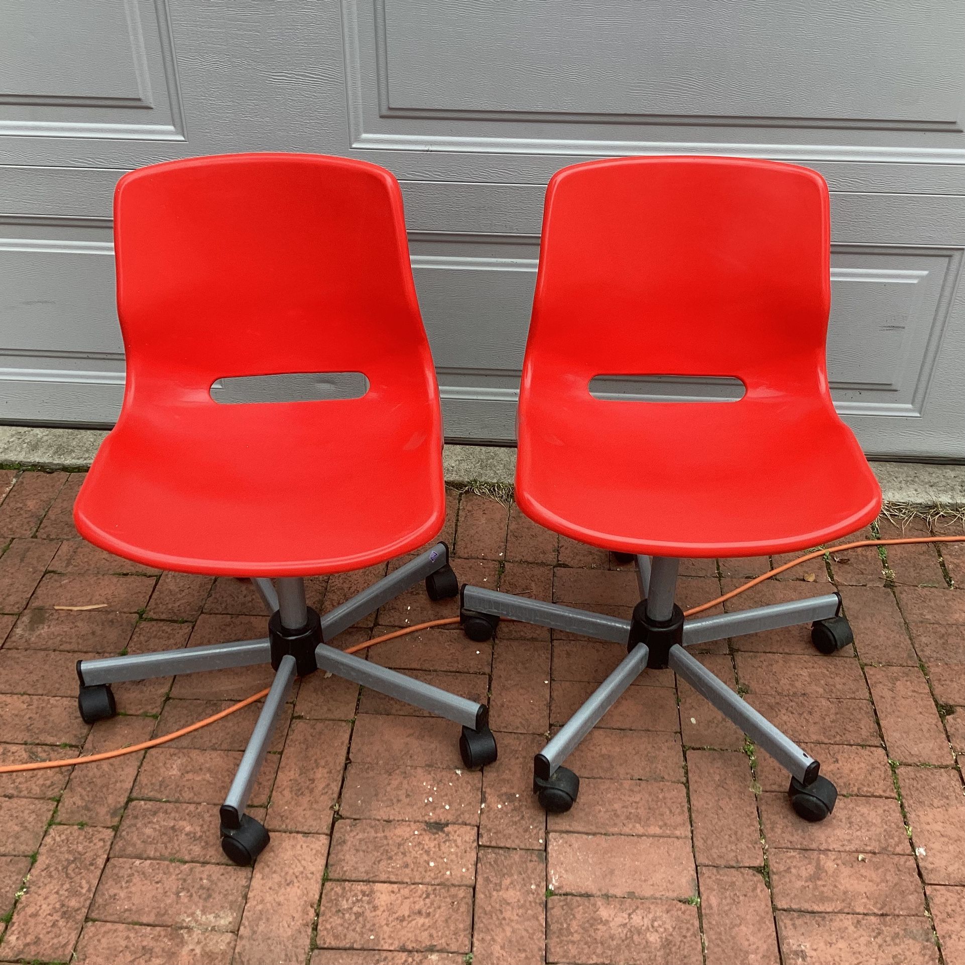Red armless plastic rolling chair - 2 items ( pair of chairs ), used, adjustable height , set. Price is for both chairs.