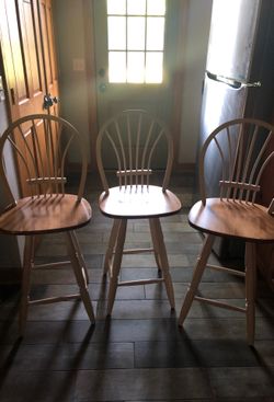 3 wooden cream swivel stools with wood seats.