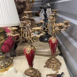 Ornate gilded bronze and red porcelain candelabra pair. Candelabra, designed to hold multiple candles, have been a symbol of wealth and status since a