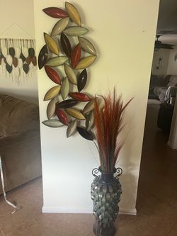 Metal wall art and metal vase with dried arrangement