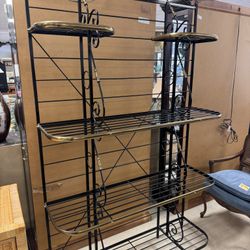 vintage baker's rack is crafted from black wrought iron with polished brass decorative details