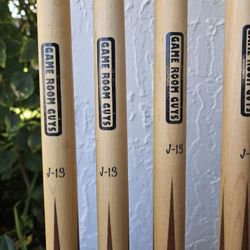 4 "Game Room Guys J-13" cues in very good, functional condition. Plus 2 Additional Assorted cues. 