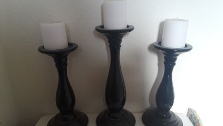 3 black pillars with white candles