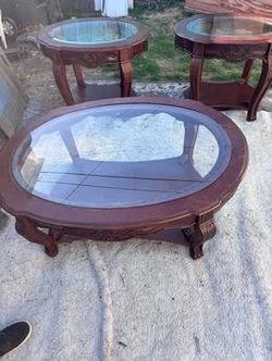 Living room table set.?three-piece traditional living room table set featuring carved wood details and glass-top inserts. In good condition. Pick up i