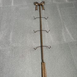 Metal wall mounted display rack for three plates featuring a bow motif and tassel ￼bottom