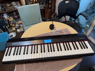The Roland GO:PIANO 61-key Portable Piano is a sleek black electronic keyboard designed by the renowned brand Roland. This model, the GO-61P, comes as