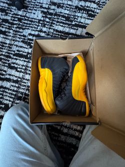 Nike Air Jordan 12 Retro sneakers in a black and university gold colorway.