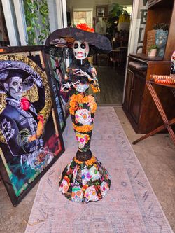 Handcrafted La Catrina figure for the Day of the Dead, made of papier-mâché and decorated with colorful floral motifs.