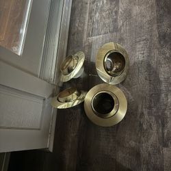 Four brass recessed light fixtures.