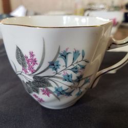 Vintage Crown England bone china teacup blue and purple flower with leaf design trimmed in gold.