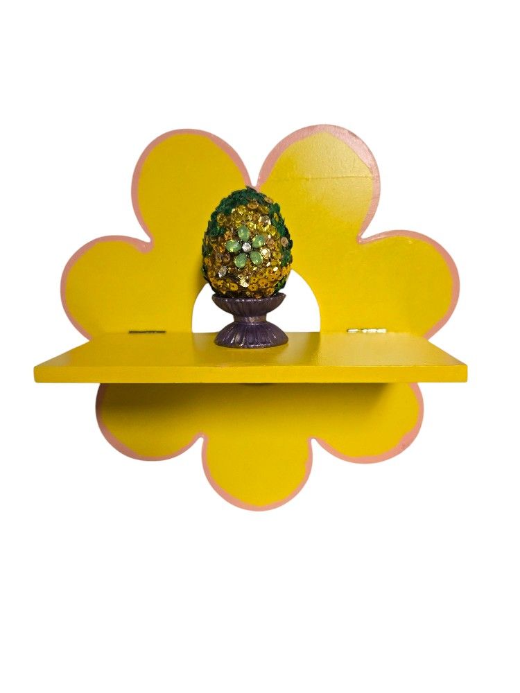 Yellow floral folding wooden shelf with sequin Easter egg in egg cup