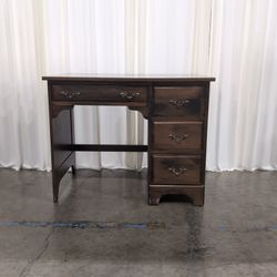 Dark Wood Four-Drawer Desk with Ornate Pulls