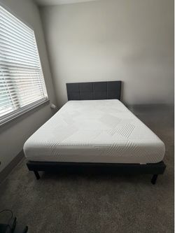 Queen bed frame with upholstered headboard for sale.
