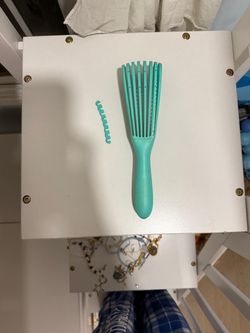 Blueish- Green hair brush that can extend sizes.