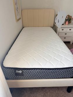 Beige upholstered twin bed frame with mattress