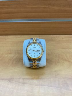 Seiko SQ wristwatch features a two-tone silver and gold design with a white dial and fluted bezel