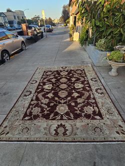 This Peshawar Oushak-style rug features a traditional floral design, hand-knotted in wool.