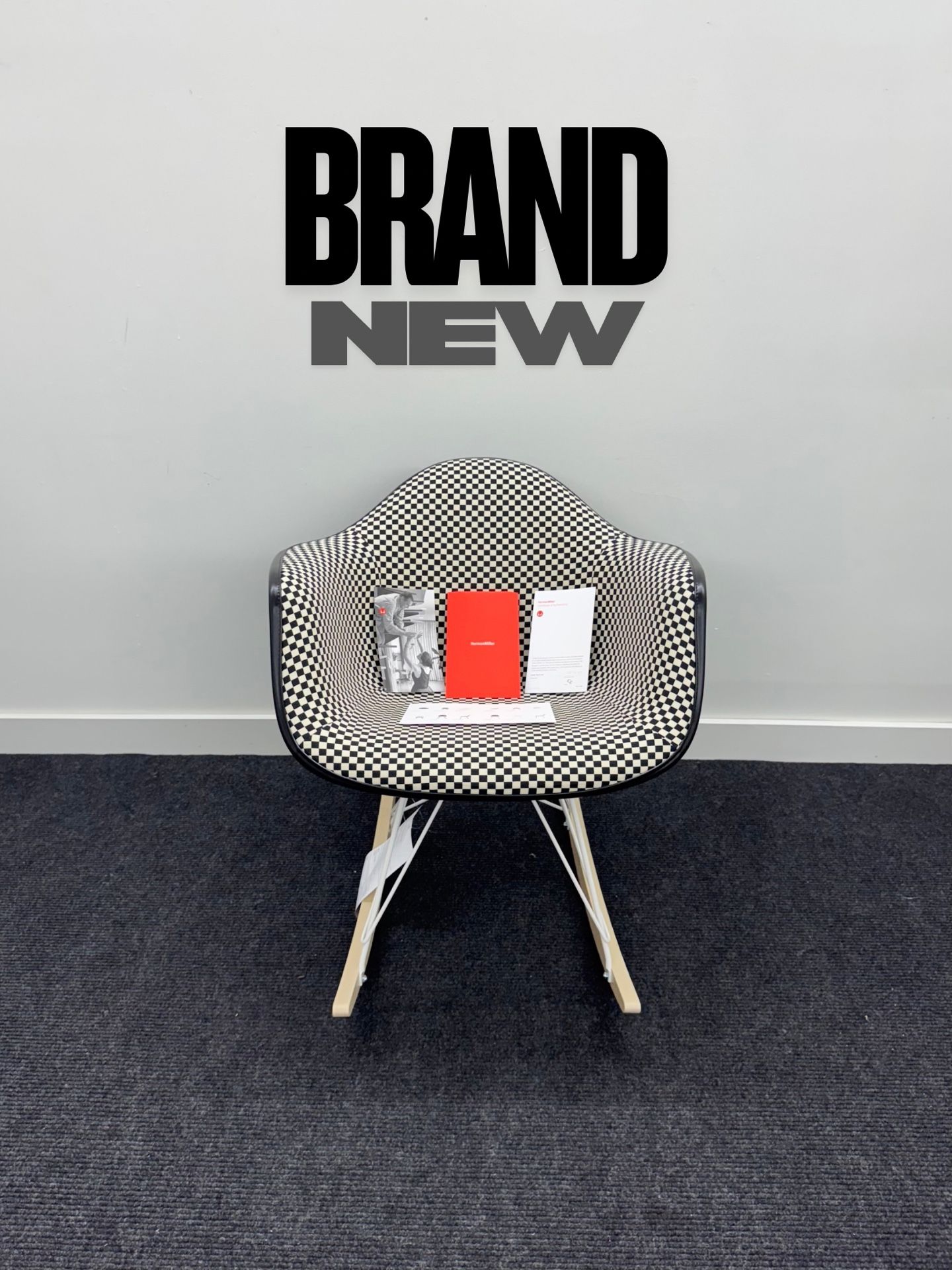 BRAND NEW HERMAN MILLER EAMES UPHOLSTERED MOLDED PLASTIC ARMCHAIR, ROCKER BASE. BLACK/WHITE CHECKERED PATTERN