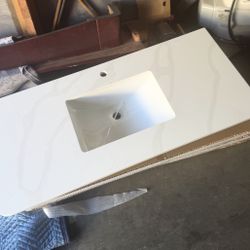 white quartz bathroom vanity top with veining, an integrated sink, and a single faucet hole.  