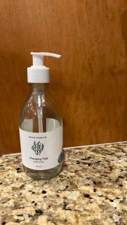 Empty glass hand soap container and matching lotion