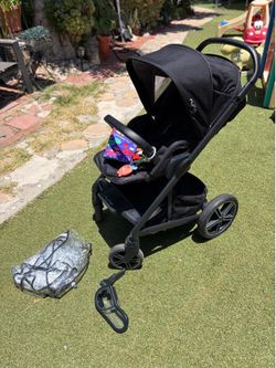 Nuna Mixx2 with Snack Tray, rain cover and baby toys.