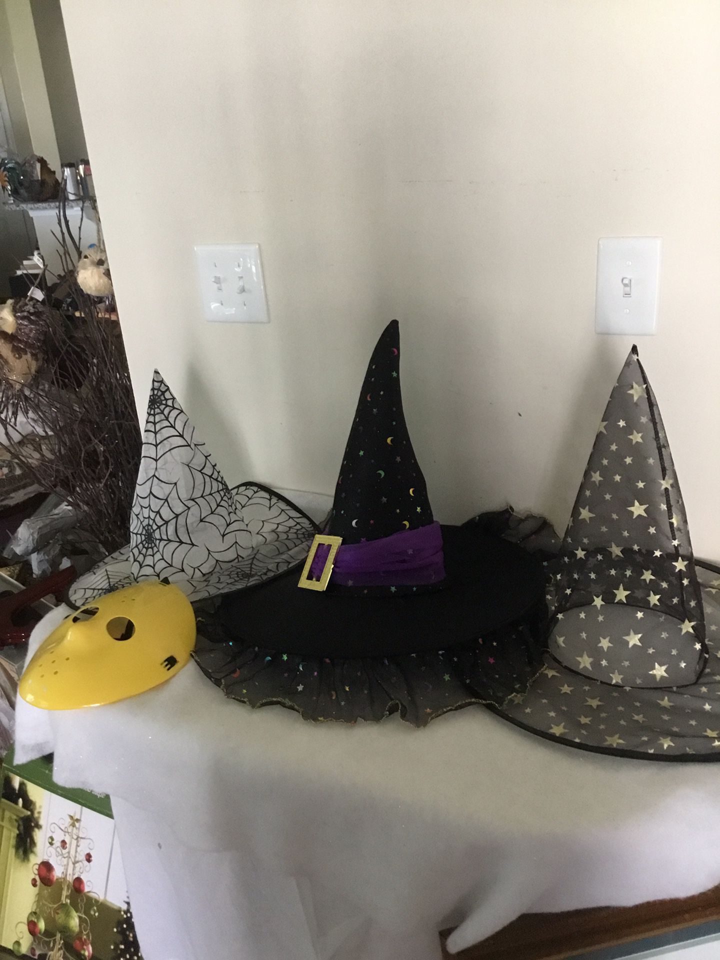Three Halloween witches hats and one plastic scary mask