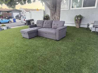 L-shaped sofa transforms into a bed and has storage, grey