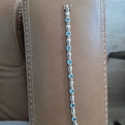 9 inch silver bracelet with blue topaz.