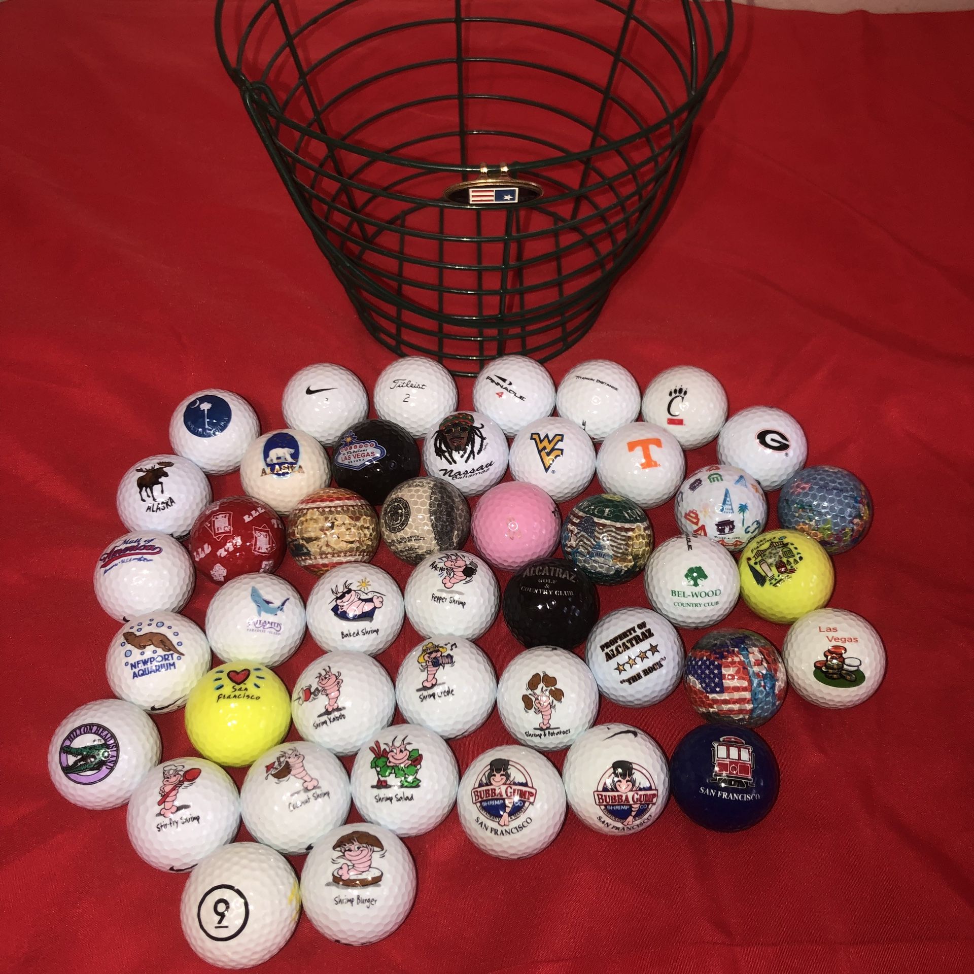 Collectible golf balls, basket, & tee marker. There’s about 45 or more golf balls from Alcatraz, San Francisco, Bubba Gump’s, Alaska, Mall of America