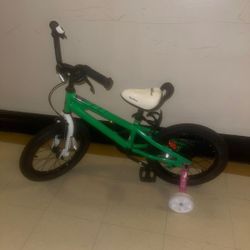 Green kids bike.  Includes training wheels.  Great for younger children learning to ride.  bicycle, likely a 14-16 inch model, designed for children a