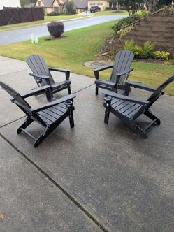 4 BRAND NEW Polywood type material foldable black Adirondack chairs with cup and wine glass holders.