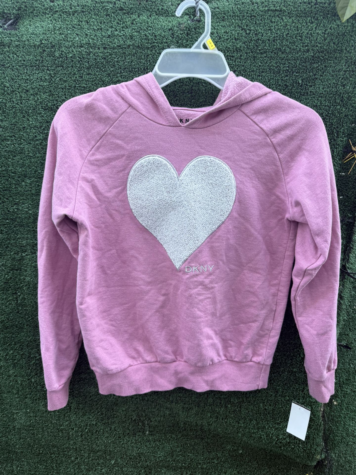 This is a pink DKNY hoodie with a bright heart in the center. Size L (12)