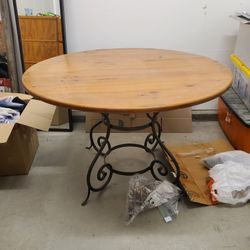 Round solid wood table with metal base. 