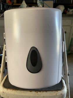 white plastic center-pull paper towel dispenser