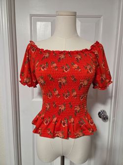 Dark orange floral blouse with ruffled sleeves and neckline