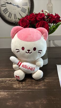 Anirollz pink/white cat plush holding a round 1 blowing pin